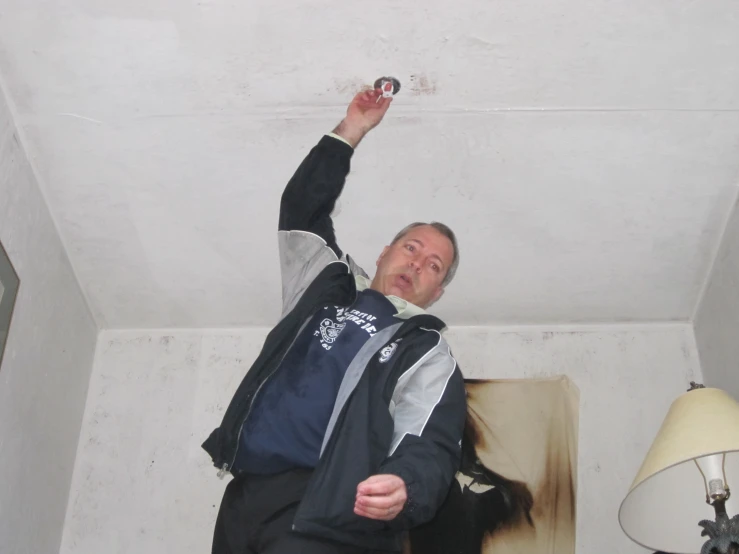 a man in a jacket is pointing at soing in the air