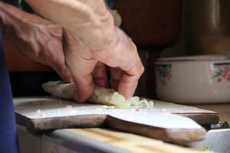 someone chopping up food on top of a  board