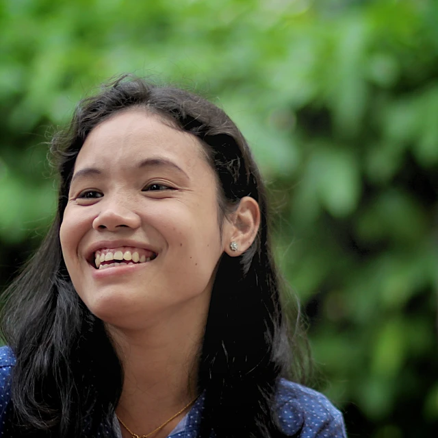 a close up of a person with long hair smiling