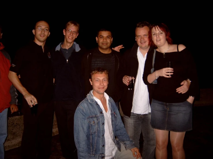 group of people standing on street at night