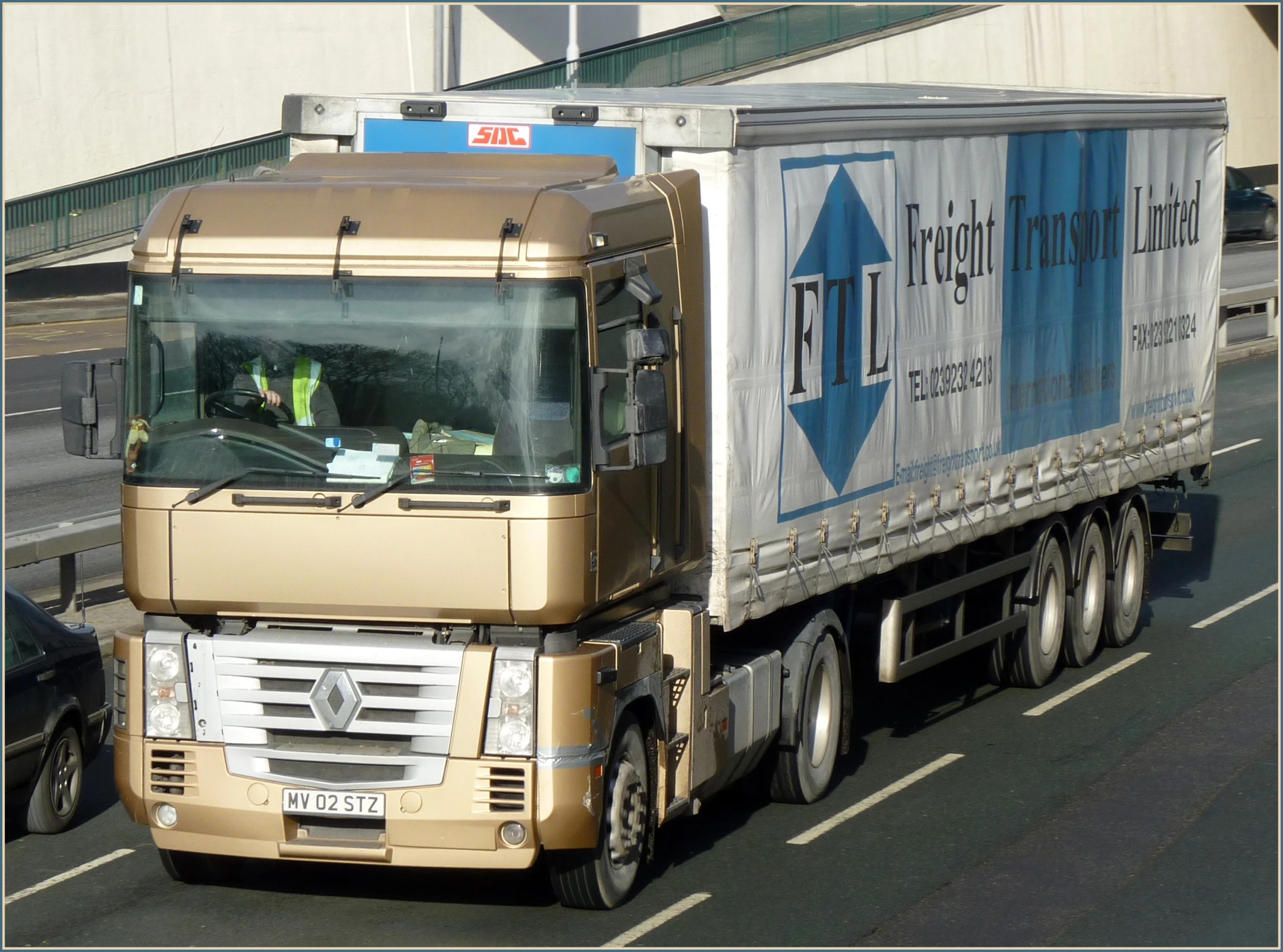 a tan truck is driving down the street