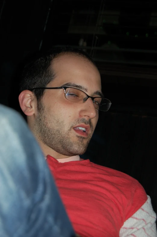 a man in glasses is looking away from the camera