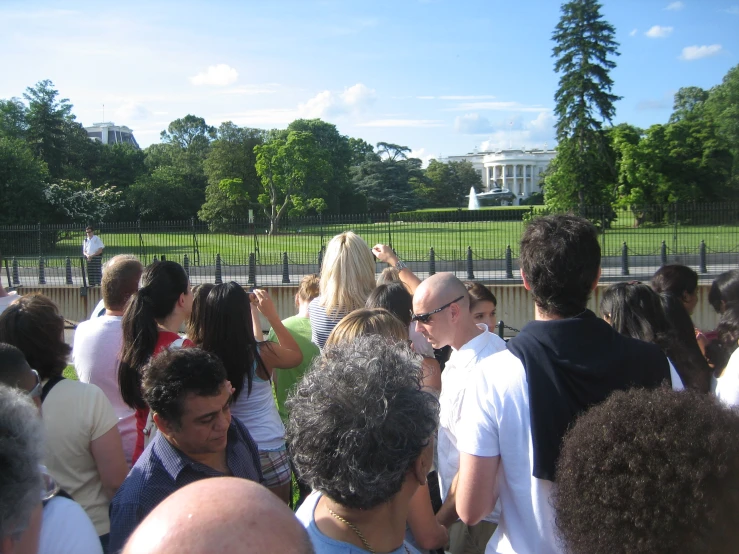 crowd of people near white house taking pictures