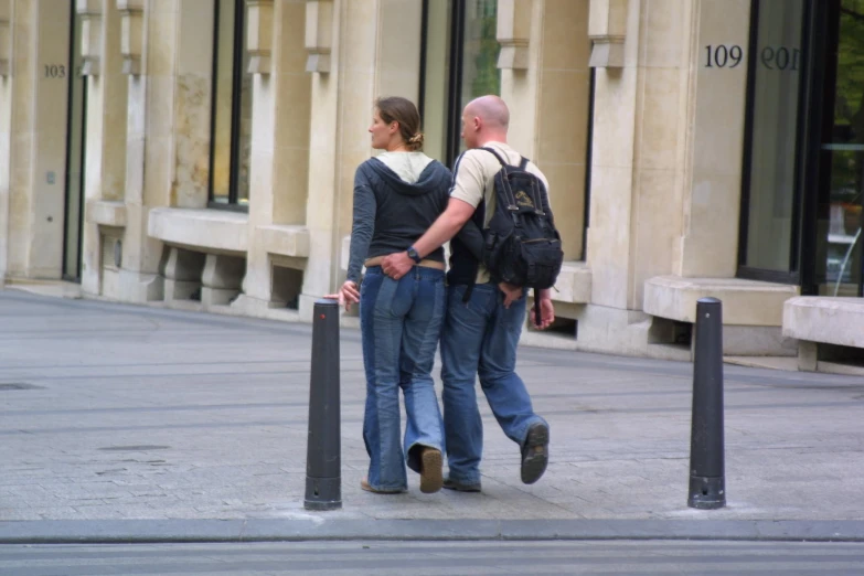 there are two men walking on the side walk