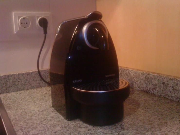 a black and silver coffee maker sitting on a granite counter