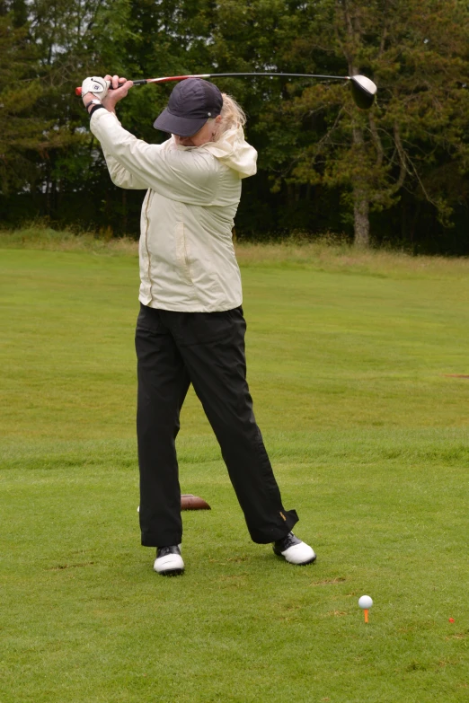 the man is practicing his swing on the golf course