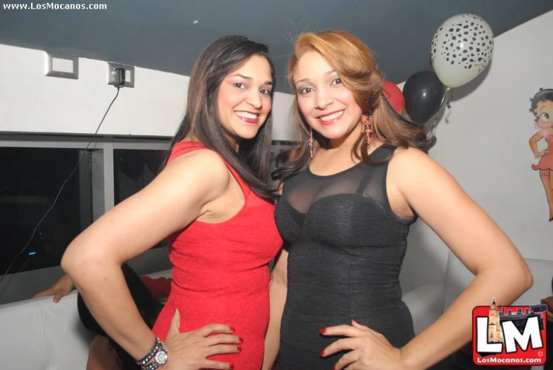 two women standing next to each other at a party