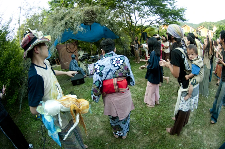 an outdoor gathering of people standing and walking