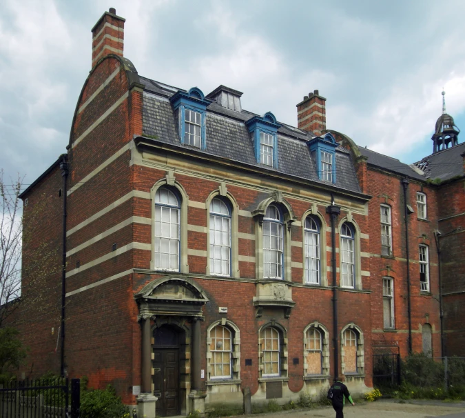 a large brick building with a small car parked outside