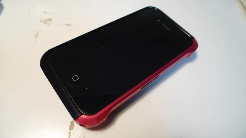 a red, black and white phone is sitting on top of the table