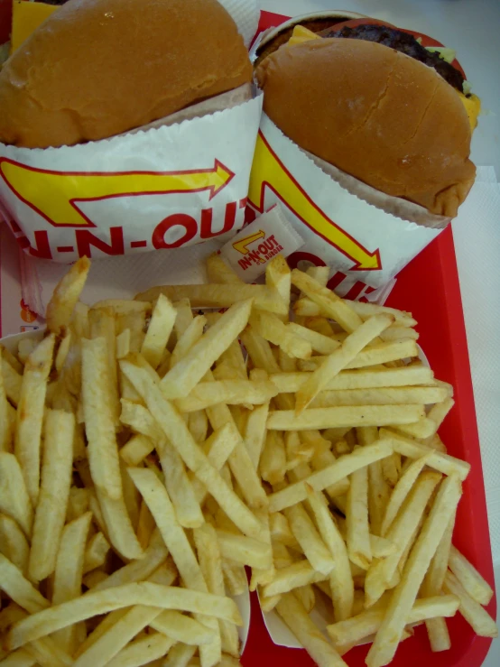 two dogs on buns and fries are in a basket