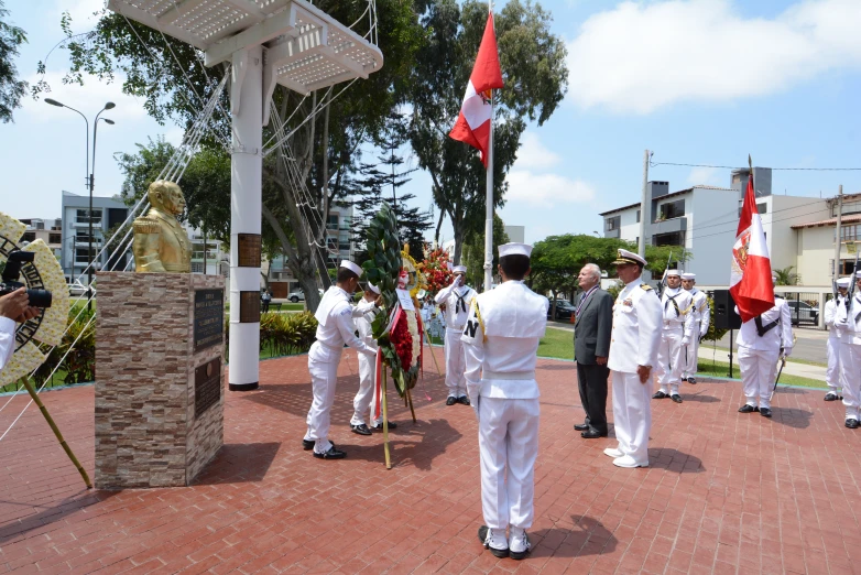 many men are standing on red brick near flags and building