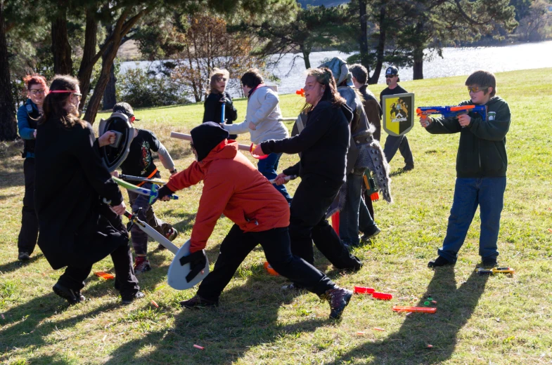 a group of people are playing with a nerf gun