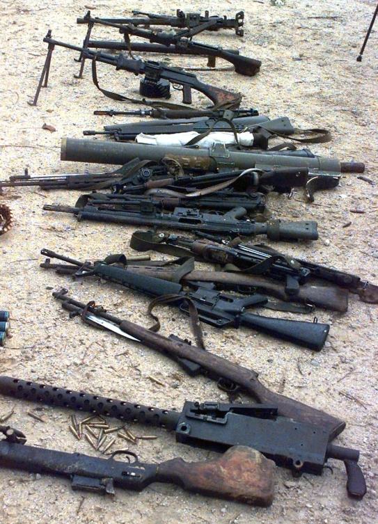 lots of weapons are on the ground in the desert