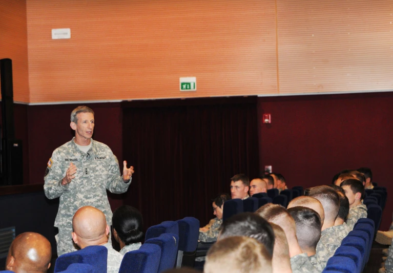 a military man standing in front of a crowd