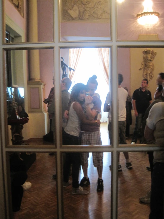 a man and woman emce in a mirror frame as people take pictures