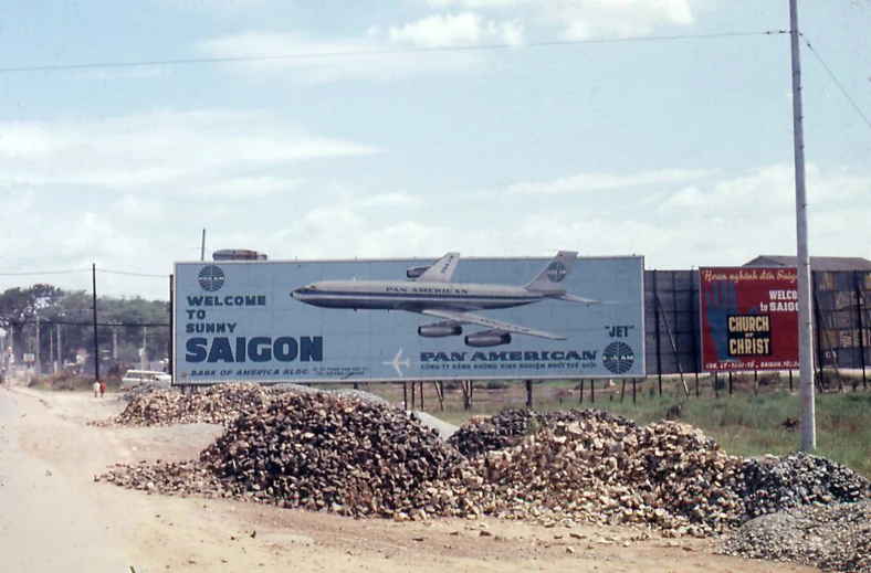 a large billboard advertising an airliner next to trees