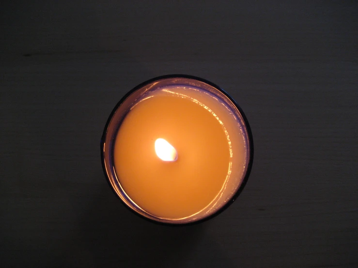 a single candle on top of a black plate