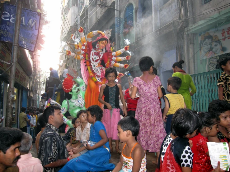 a large group of people gathered on a street with float on a truck