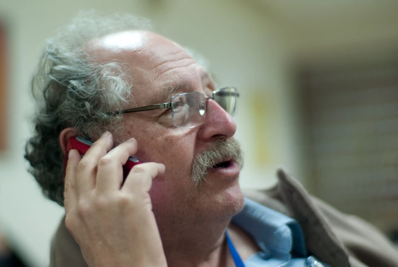 a man with glasses on a cell phone