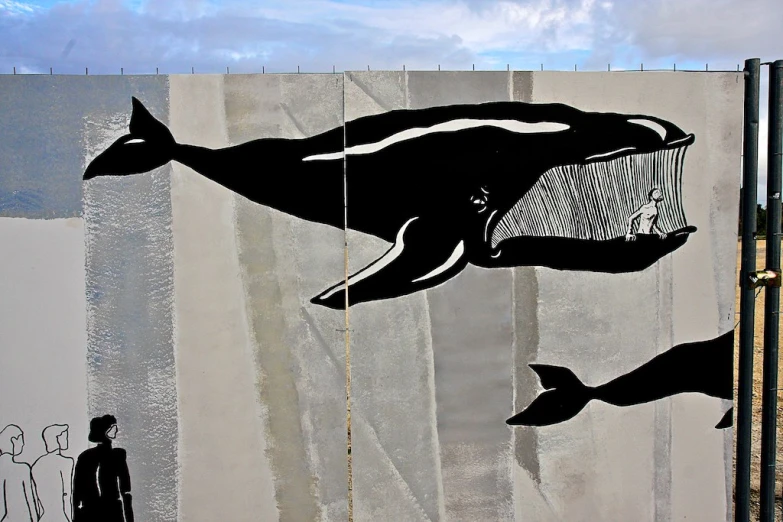 a black and white mural depicting a whale