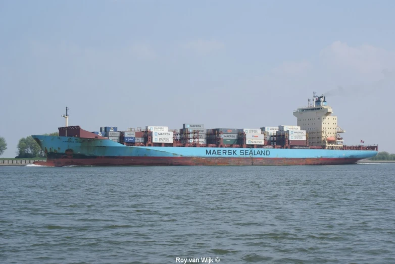 a huge ship with a bunch of containers on it is in the water