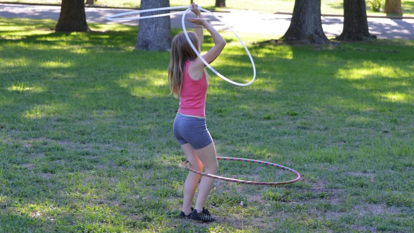 a little girl playing with a hula hoop