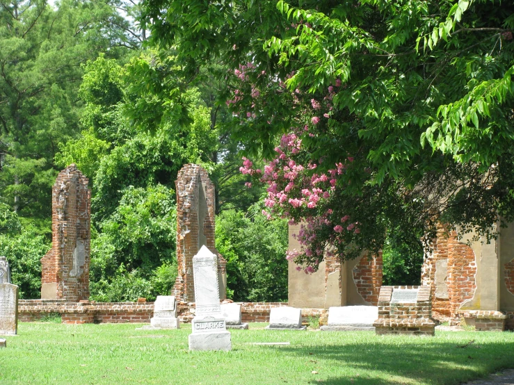 a cemetery in the grass with brick pillars