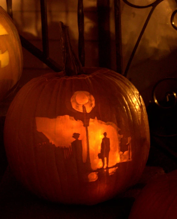 a lit up pumpkin sitting next to other carved pumpkins