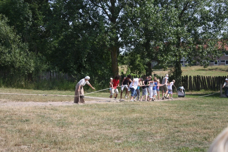 a group of people with a fence in the grass