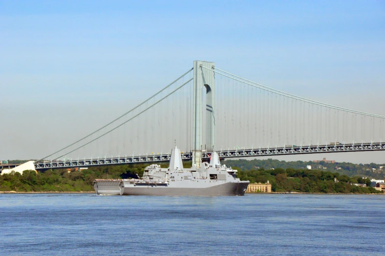 two ships sailing close to each other in front of a bridge