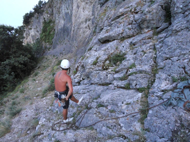 man on mountain climbing in outdoor area near grassy area