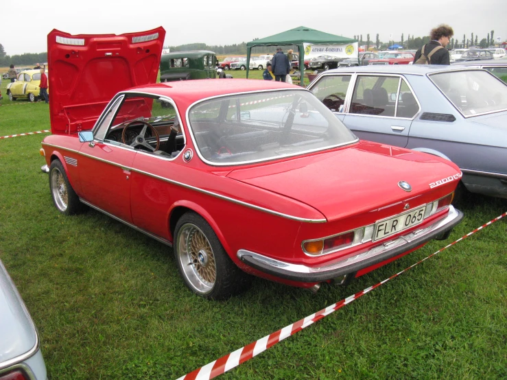 many old cars sitting on a grass field