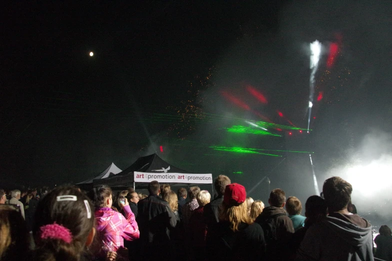 large group of people watching and looking at fireworks on the sky