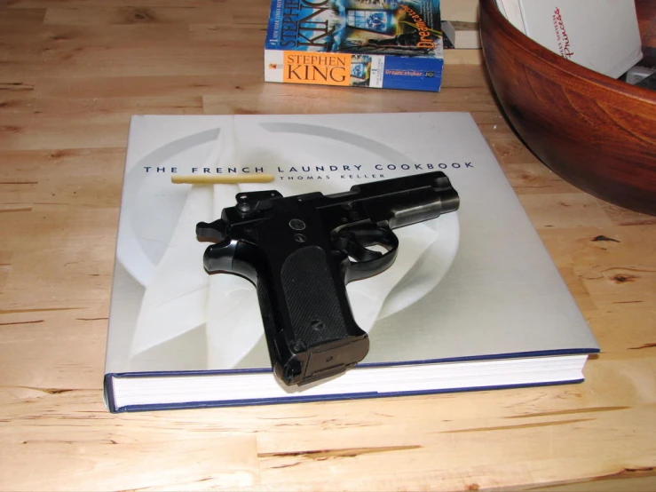 a gun and a book on a table