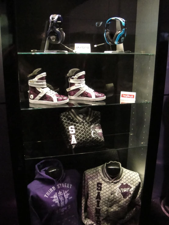 two sports apparel on shelves under a glass case