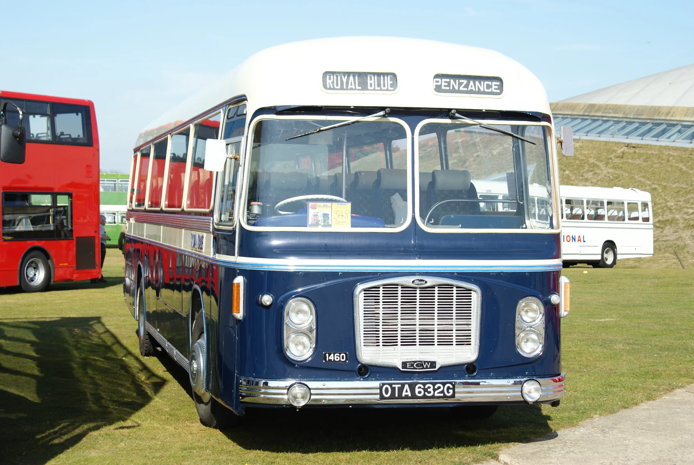 an old bus with a bus on it's front end parked in the grass