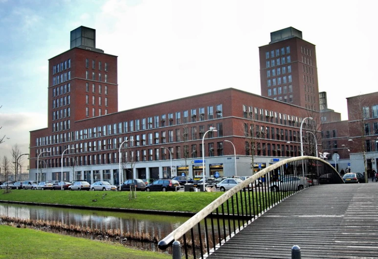 a bridge across a river leading to a large brick building