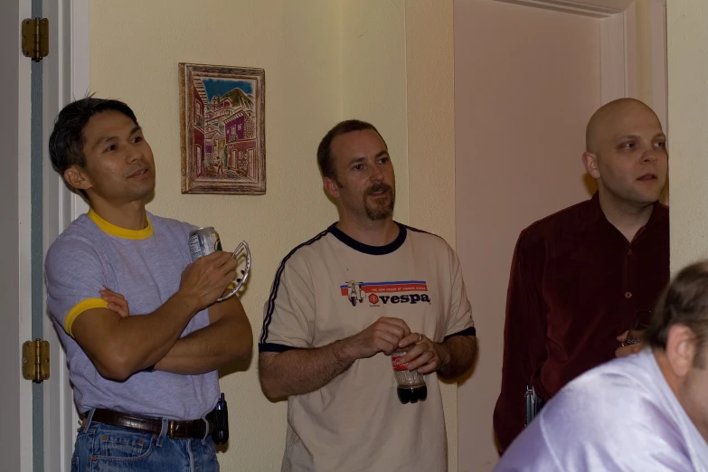 four men standing next to each other in a hallway