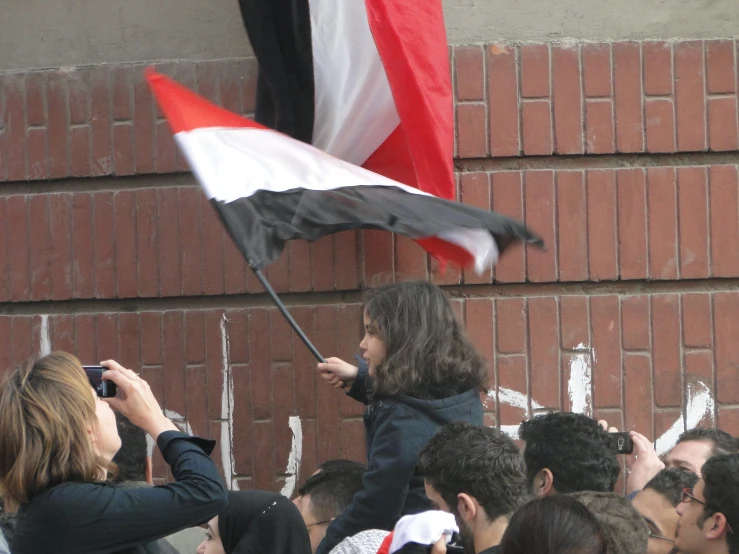 a woman holding a flag while another girl pographs her