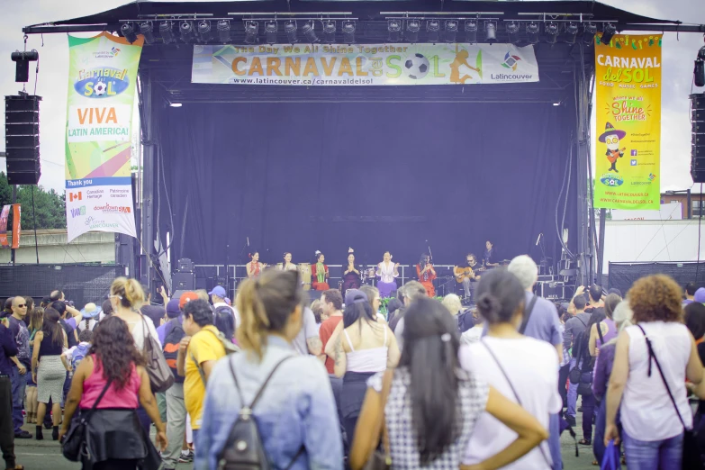 the crowd watches performers on stage as an audience looks on