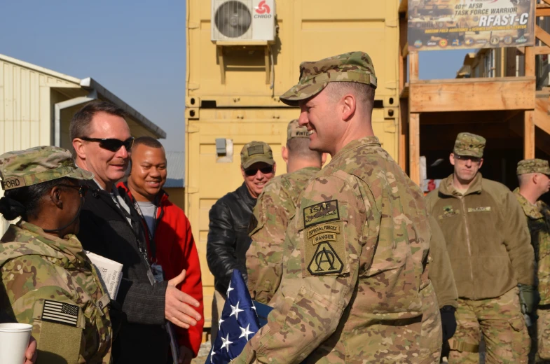 soldiers greeting a woman in the center with other people