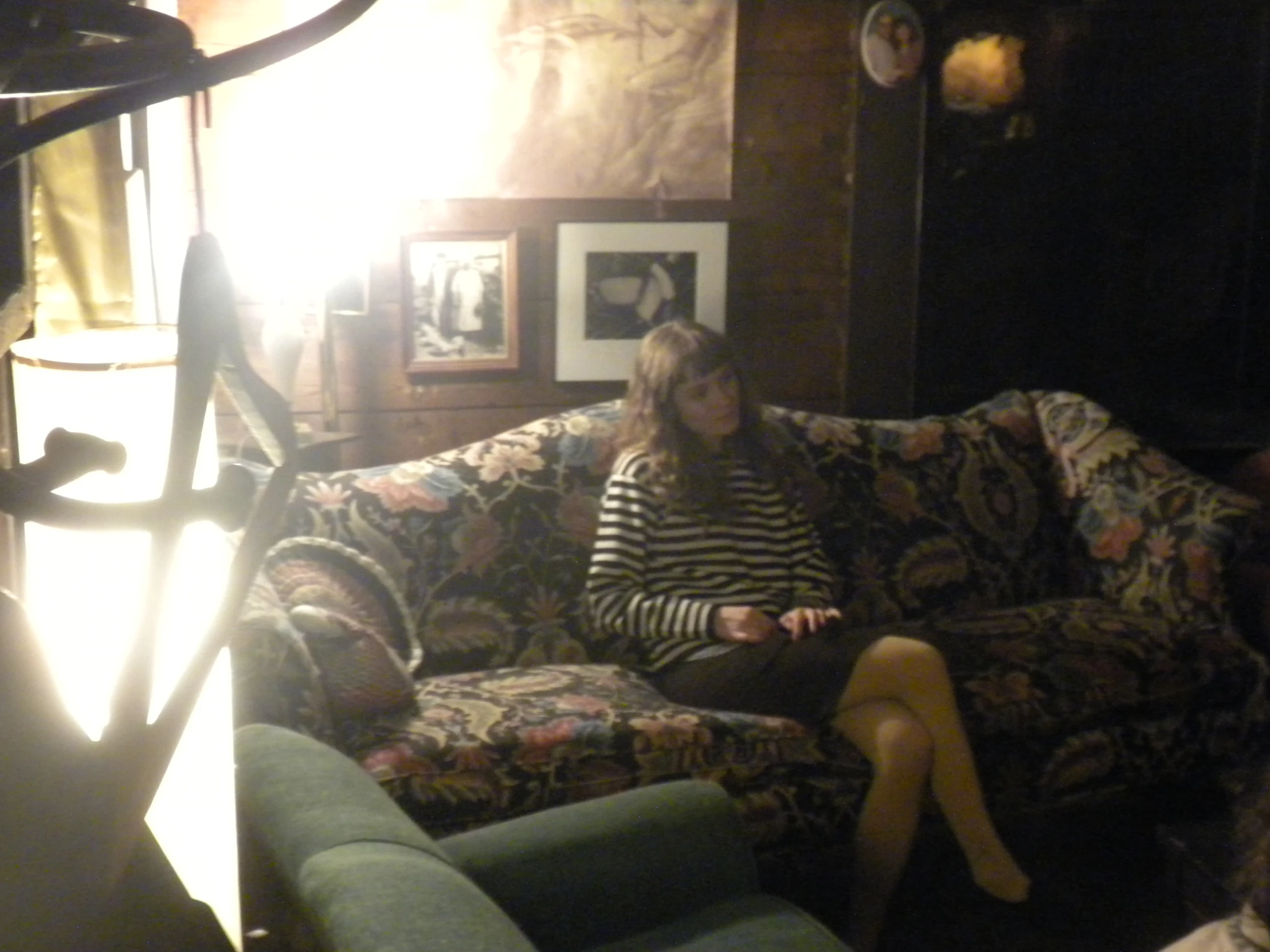 a woman sitting on a couch with colorful couch pillows