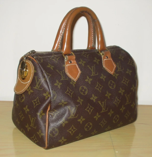 a brown louis vuitton purse sitting on top of a table