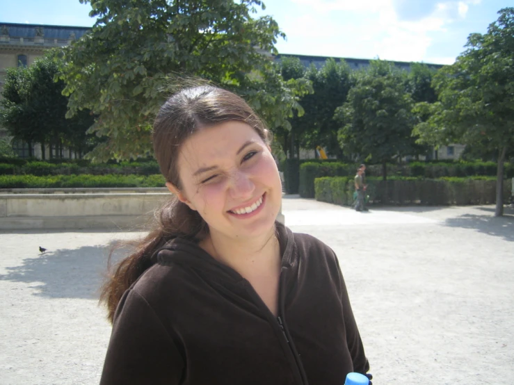 a girl with a cup smiling for the camera