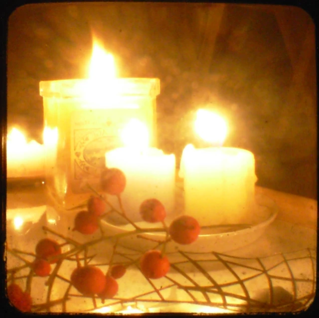 a plate of cherries with candles in the background