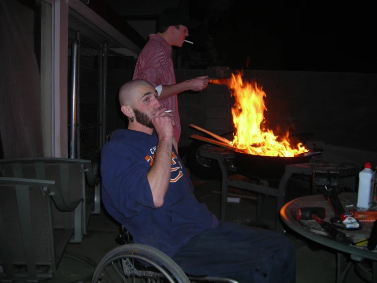 a man on his cellphone sits in front of a bbq