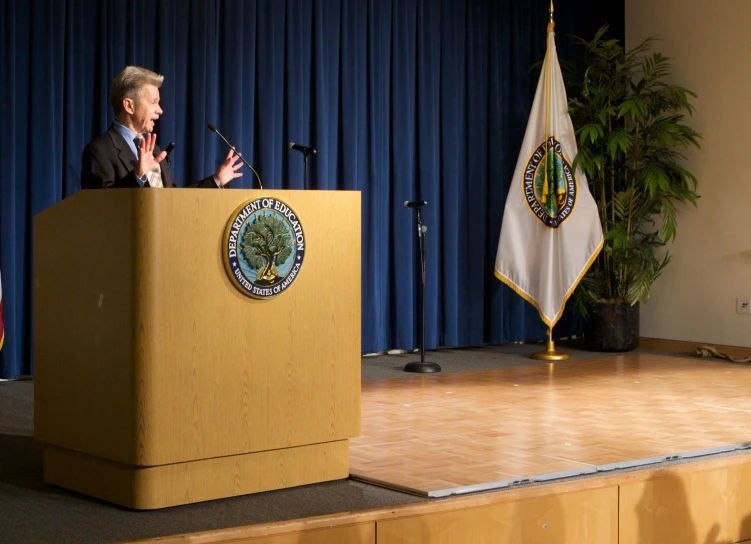 a man that is standing at a podium with a microphone