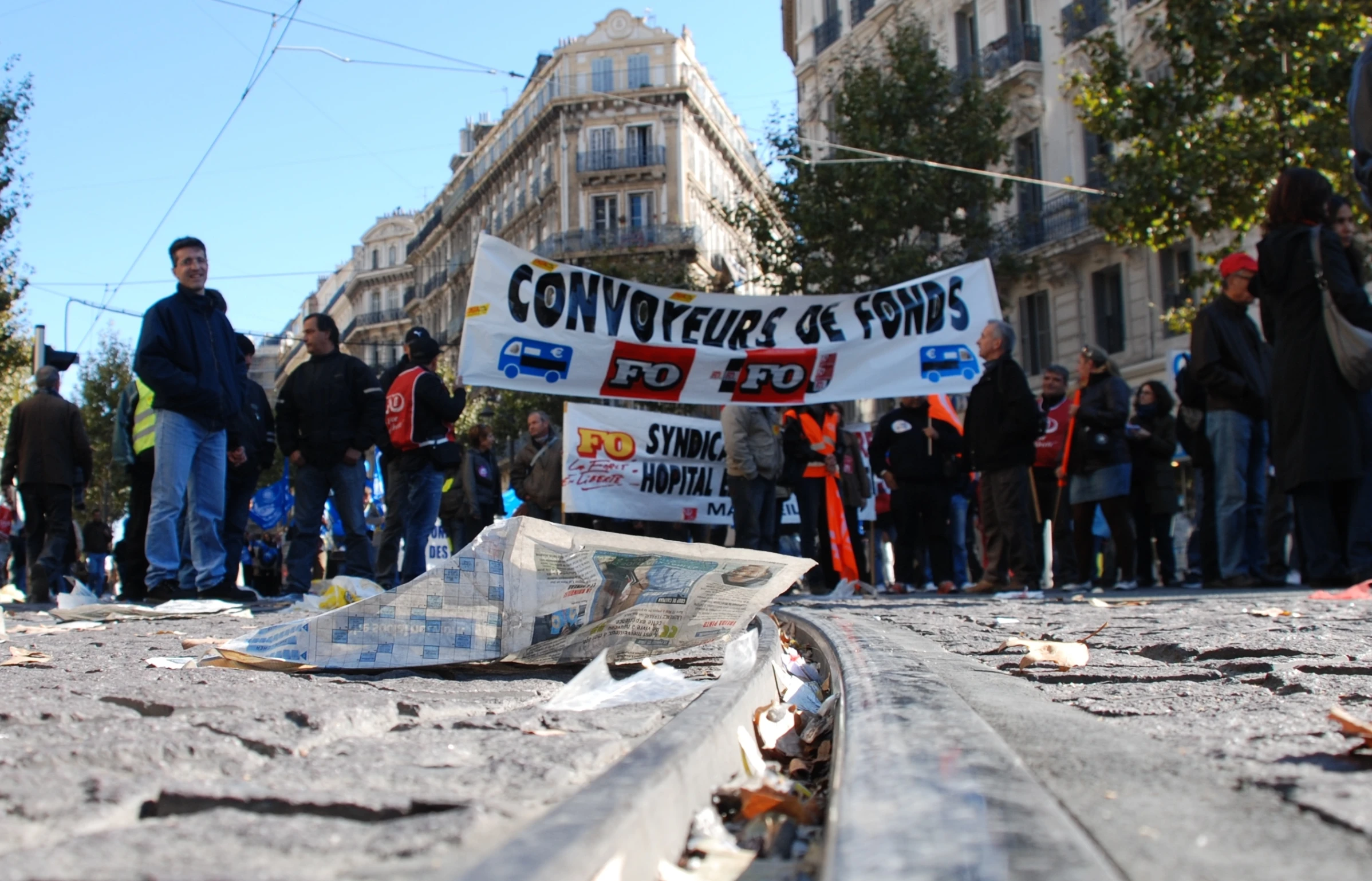 a group of people standing around the ground with signs hanging off of it