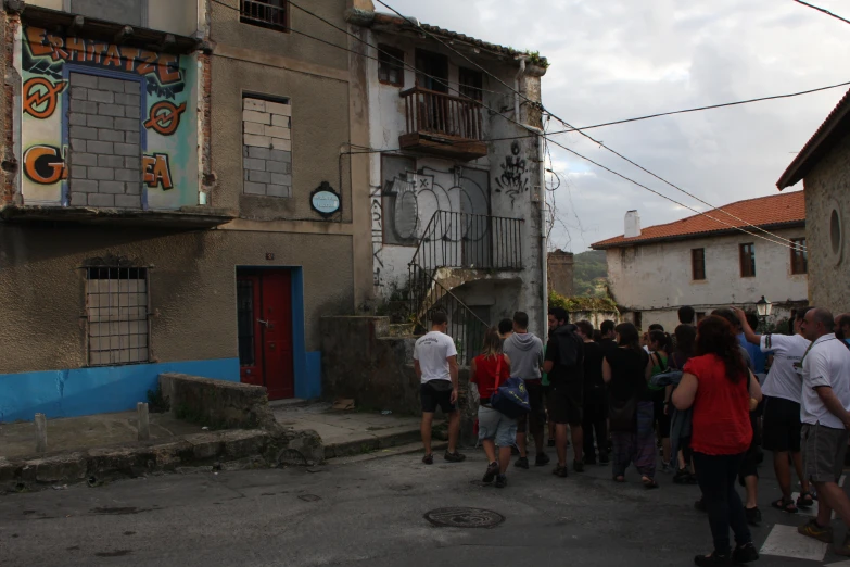 a bunch of people are on the sidewalk and some buildings